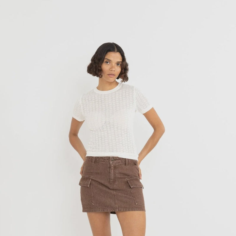 Woman wearing a white top and brown skirt on a white background
