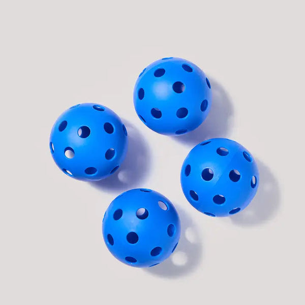 Four blue perforated balls on a light gray background