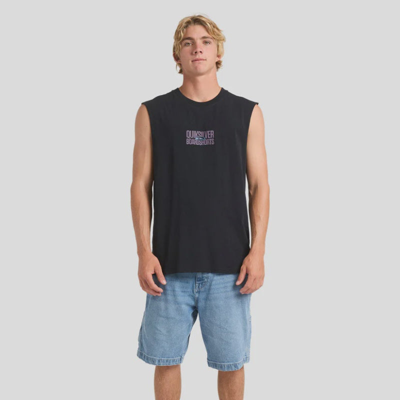 Man wearing a black sleeveless shirt with text and denim shorts on a white background
