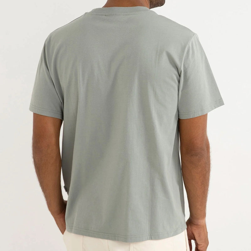 Man wearing a light gray t-shirt and sunglasses on a white background
