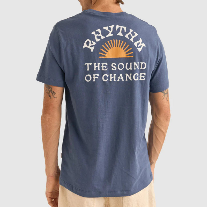 Person wearing a blue t-shirt with 'Rhythm: The Sound of Change' text on the back.