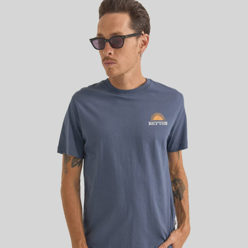Man wearing a blue t-shirt with a logo on a gray background