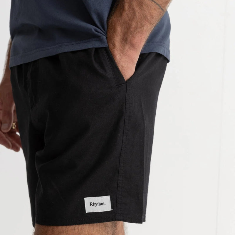 Person wearing black shorts with a visible brand logo on a white background
