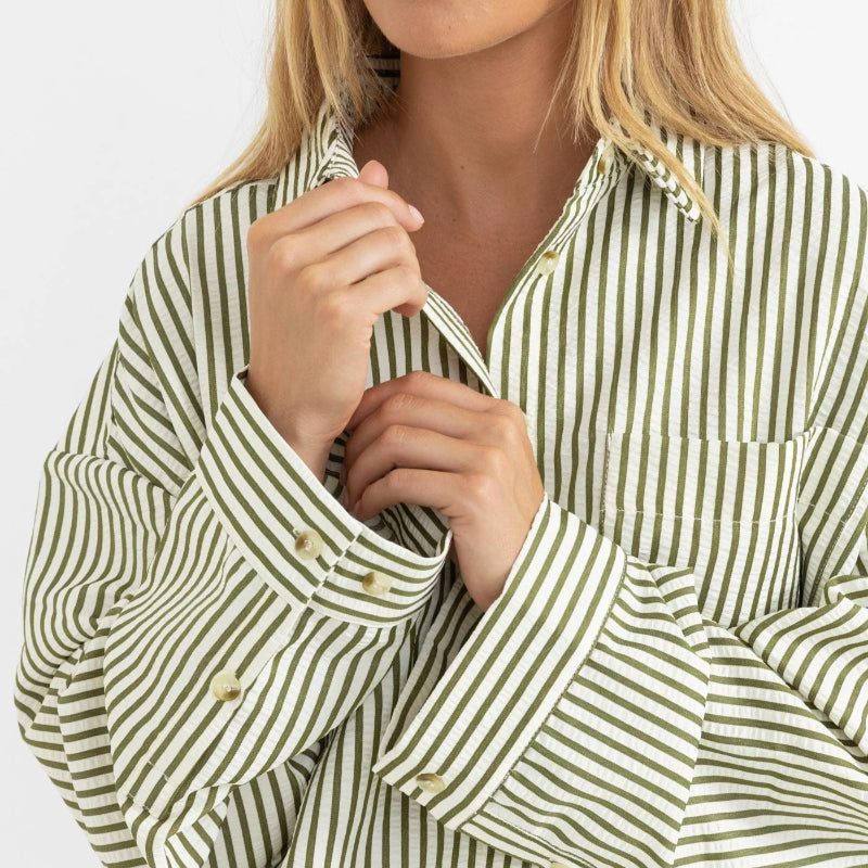Woman wearing a green and white striped shirt on a white background