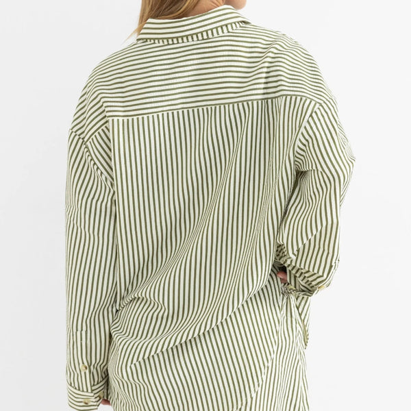 Person wearing a green and white striped shirt with shorts on a white background