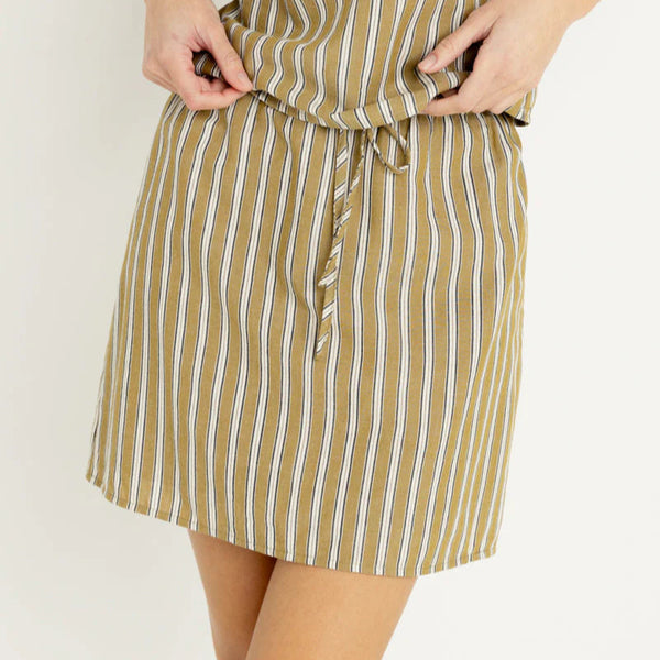 Woman wearing a striped top and skirt with a white background