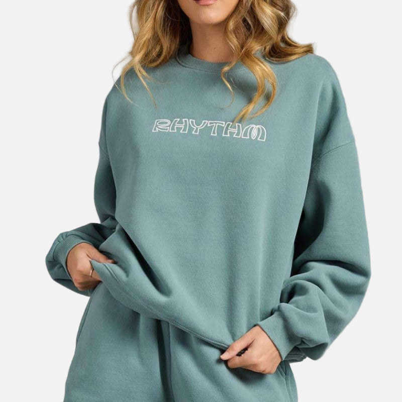 Person wearing a teal outfit with 'RHYTHM' branding on a gray background