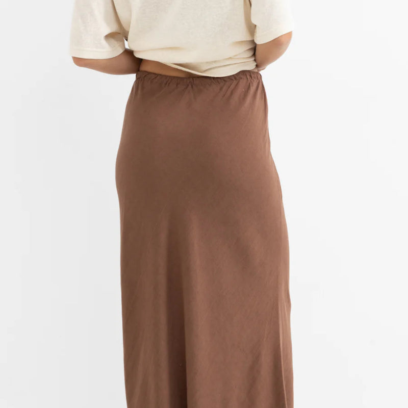 Brown maxi skirt worn by a person on a white background
