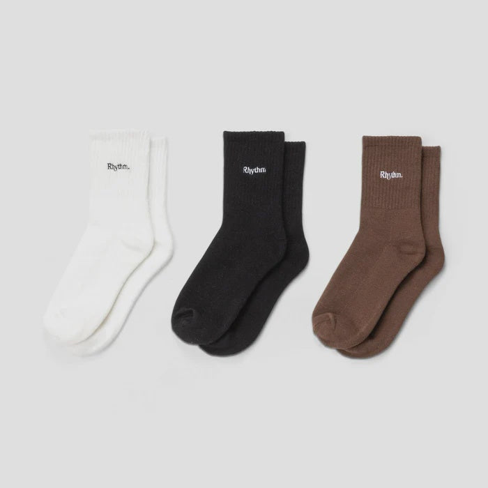 Three pairs of socks in white, black, and brown on a light gray background
