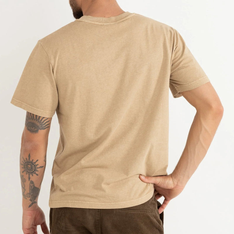 Man wearing a beige t-shirt and brown pants on a white background
