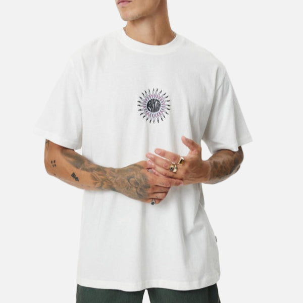 Man wearing a white t-shirt with a black sun design on a plain background