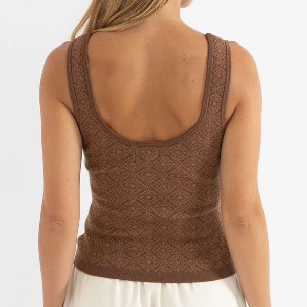 Woman wearing a brown knitted tank top on a white background