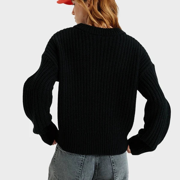 Person wearing a black sweater and red cap from behind on a light gray background