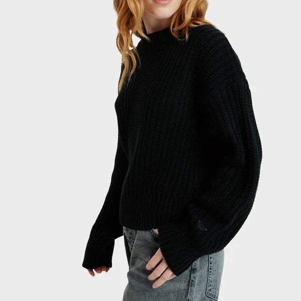 Person wearing a black sweater and red cap on a white background