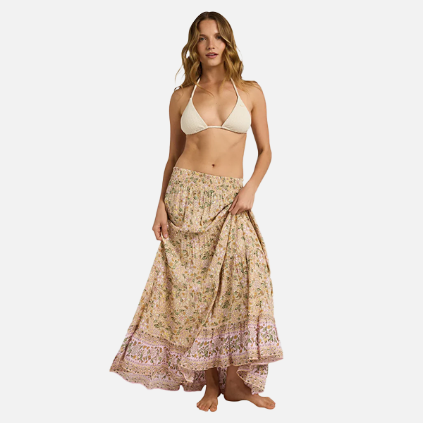 Woman wearing a beige bikini top and floral skirt on a white background