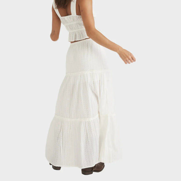 Woman wearing a white dress with a plain background