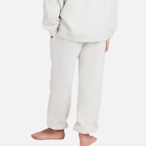 Person wearing light gray sweatpants and a matching hoodie on a white background