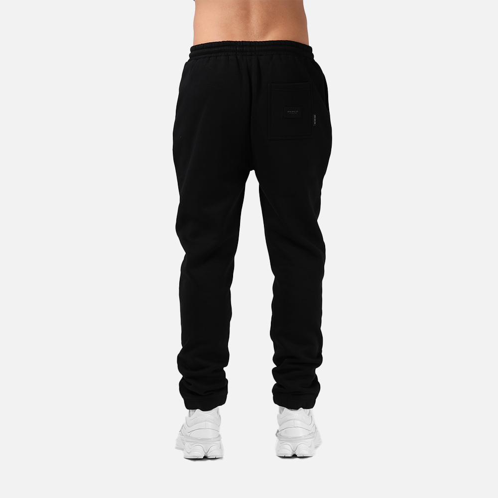 Black sweatpants worn by a person on a white background