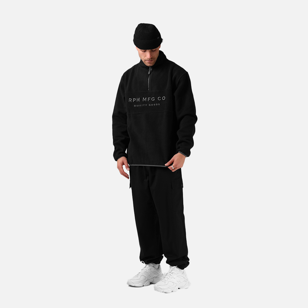 Person wearing a black tracksuit with 'RPM MFG CO' logo on a white background