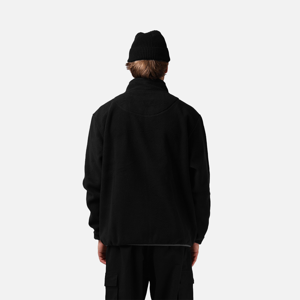 Person wearing a black jacket and beanie on a white background