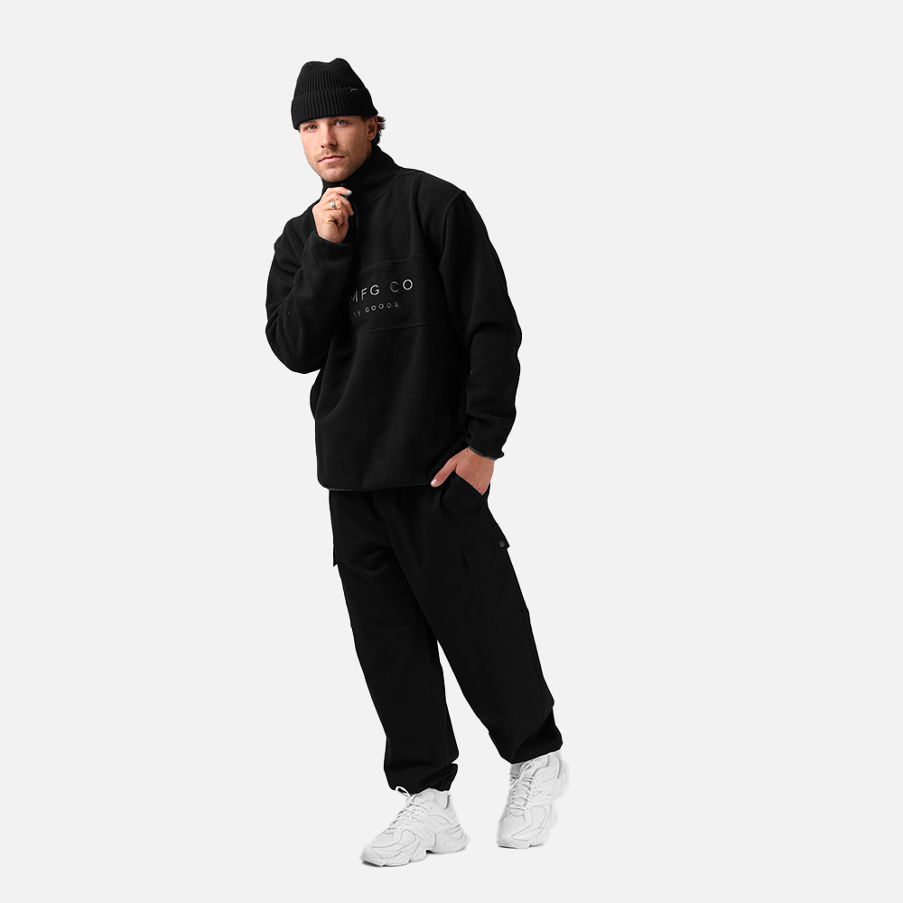 Person wearing a black tracksuit with a logo on a white background
