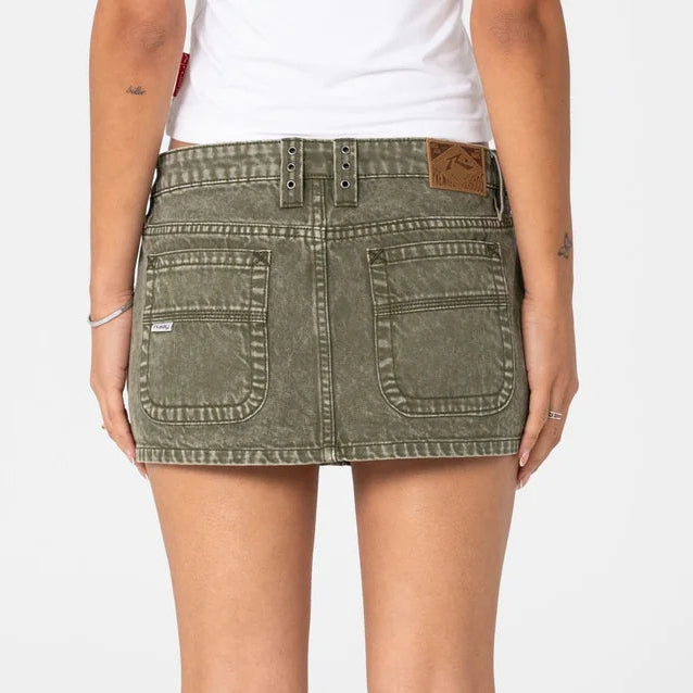 Person wearing a green denim skirt on a white background