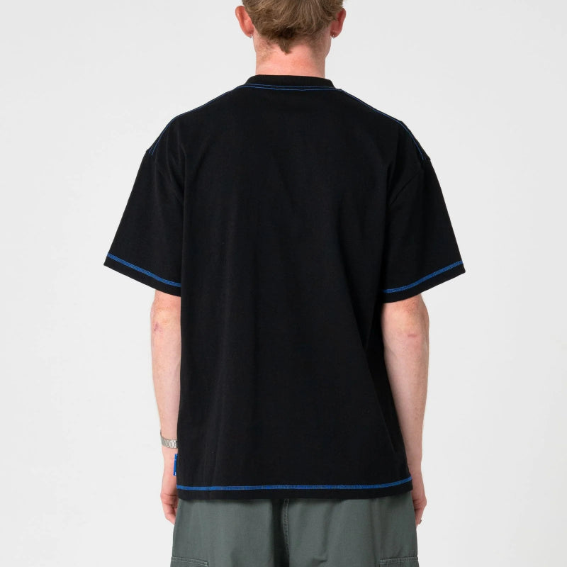 Person wearing a black tshirt with blue trim on a white background