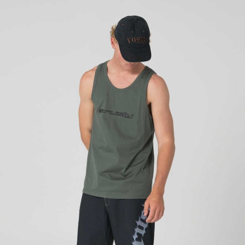 A man modeling an olive green sleeveless tank top and black athletic shorts against a light gray studio background. The tank top has a black logo across the chest, and the shorts feature a white graphic on the left leg.