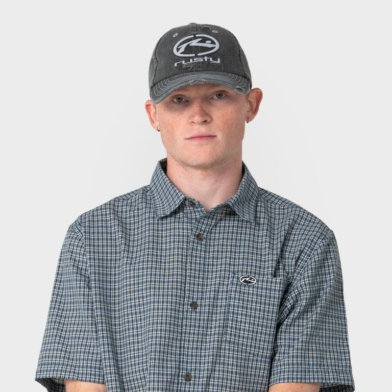Man wearing a checkered shirt and cap with a logo on a white background