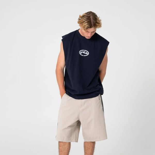 Person wearing a navy sleeveless shirt with a logo, beige shorts, and black sneakers on a white background