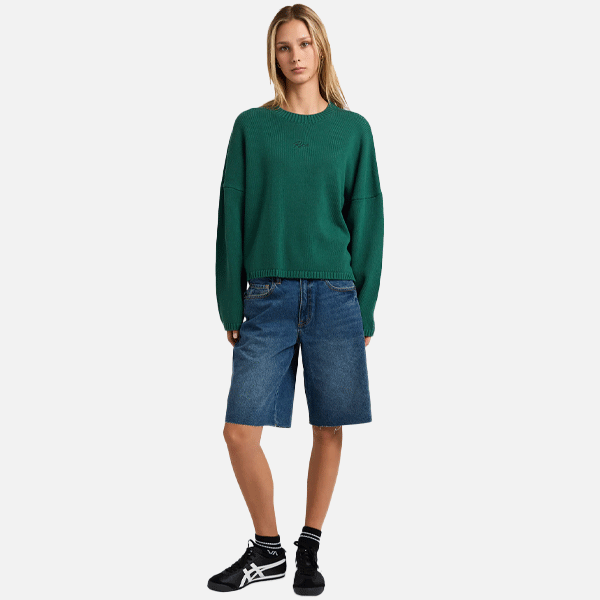 a women with a green sweeter and blue shorts on