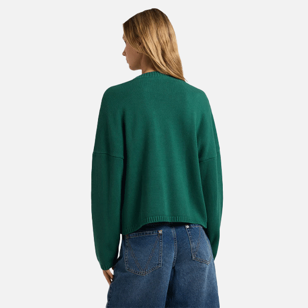 a women with a green sweeter and blue shorts on