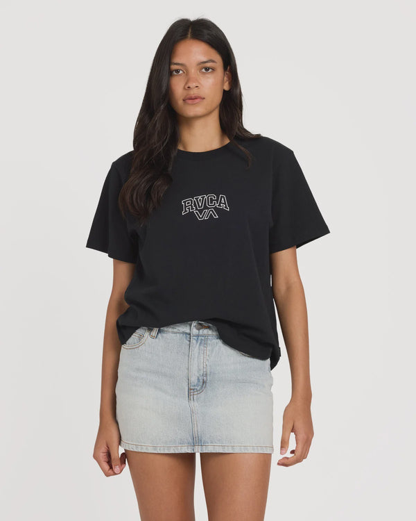 Woman wearing a black t-shirt with RVCA logo and a denim skirt on a white background
