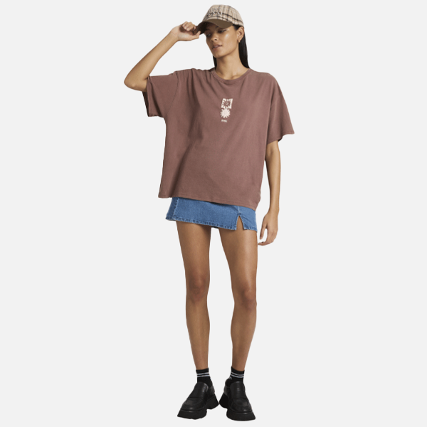 Person wearing a brown oversized t-shirt and blue denim skirt on a white background