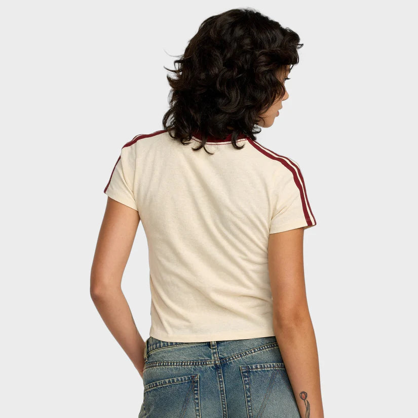 Person wearing a cream t-shirt with red stripes and blue jeans on a plain background