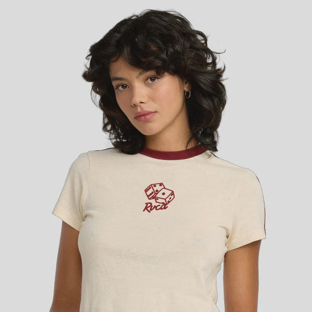 Person wearing a beige crop top with a logo and blue jeans on a plain background