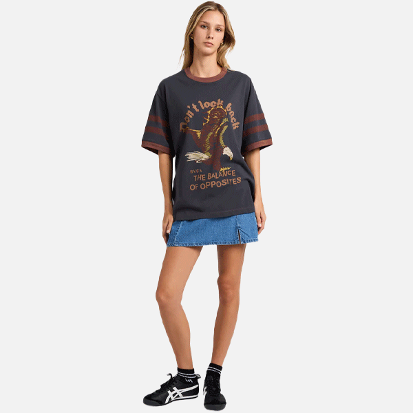 a women wearing a black and brown t-shirt with a big logo on the front