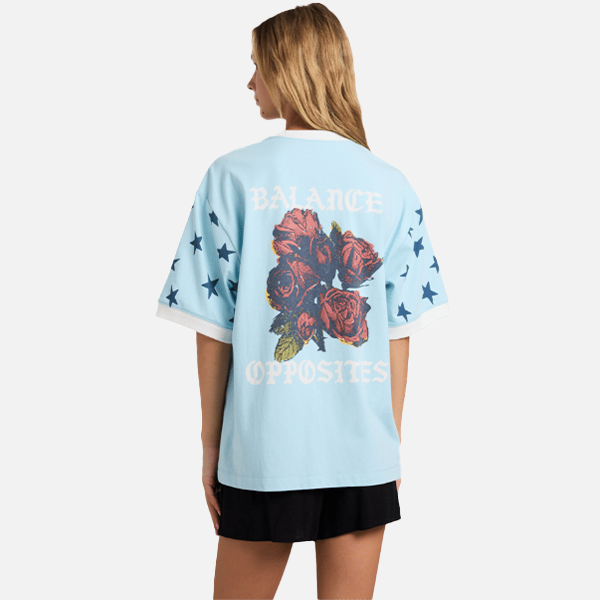 Light blue t-shirt with floral design and text worn by a person on a white background