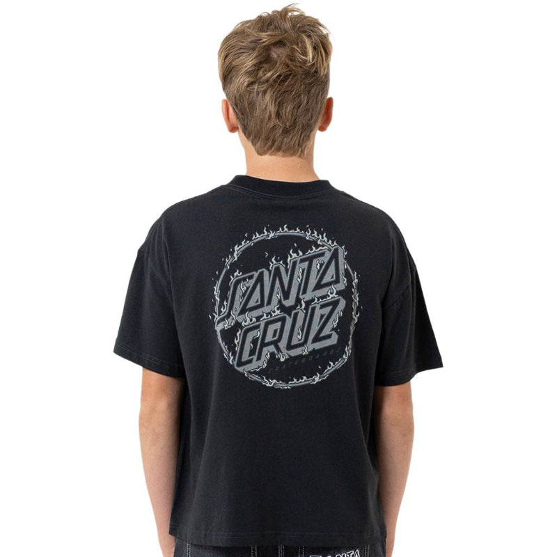 A boy viewed from behind wearing a black Santa Cruz t-shirt with a large gray graphic on the back and dark wash jeans.