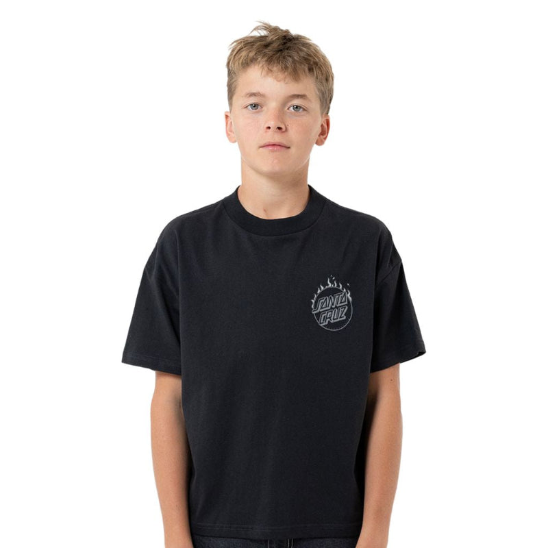 A young male model wearing a black crewneck t-shirt with a small circular graphic on the left chest, paired with dark jeans, shot against a solid white background.