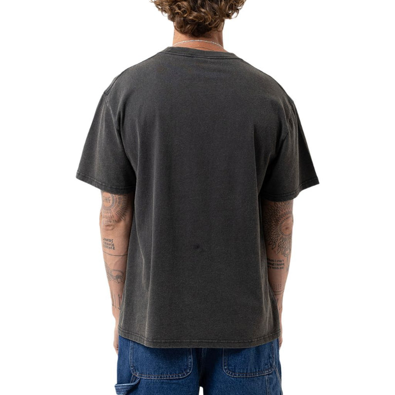 A man viewed from behind wearing a faded black t-shirt and blue jeans, standing against a solid white background.