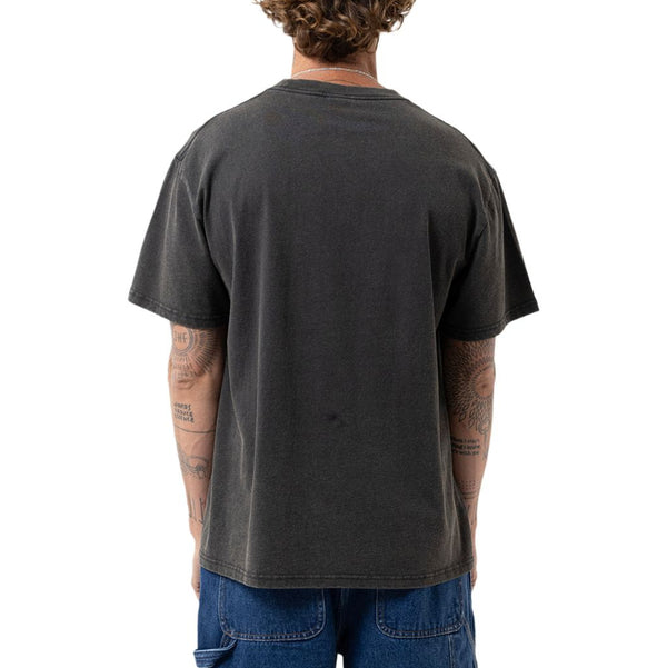 A man viewed from behind wearing a faded black t-shirt and blue jeans, standing against a solid white background.