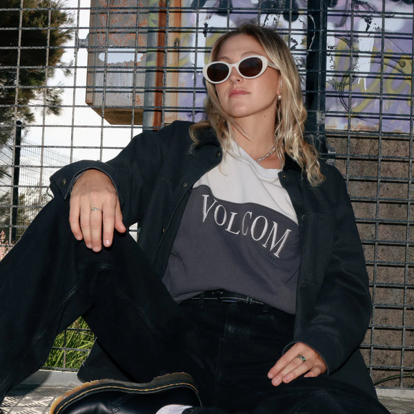 Person wearing a Volcom shirt sitting on a bench.