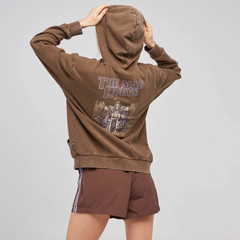 A model from behind wearing a brown cropped hoodie with a graphic print on the back, paired with matching brown shorts, white socks, and black sneakers, against a light gray studio background.