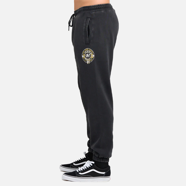 Black sweatpants with a logo on the side worn by a person, on a white background