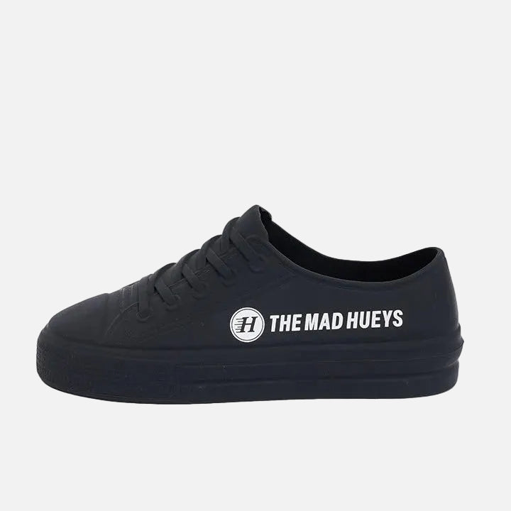 Black sneaker with 'The Mad Hueys' logo on a gray background