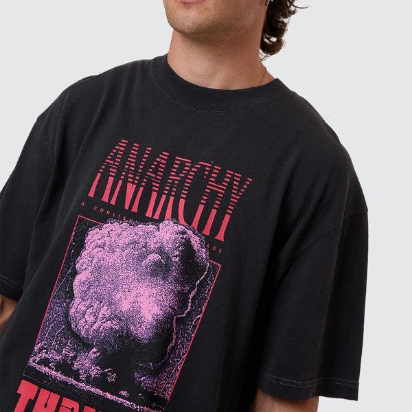Person wearing a black t-shirt with pink and red graphics and text.