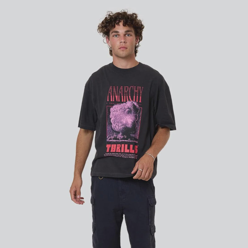 Person wearing a black t-shirt with graphic design and text, standing against a white background