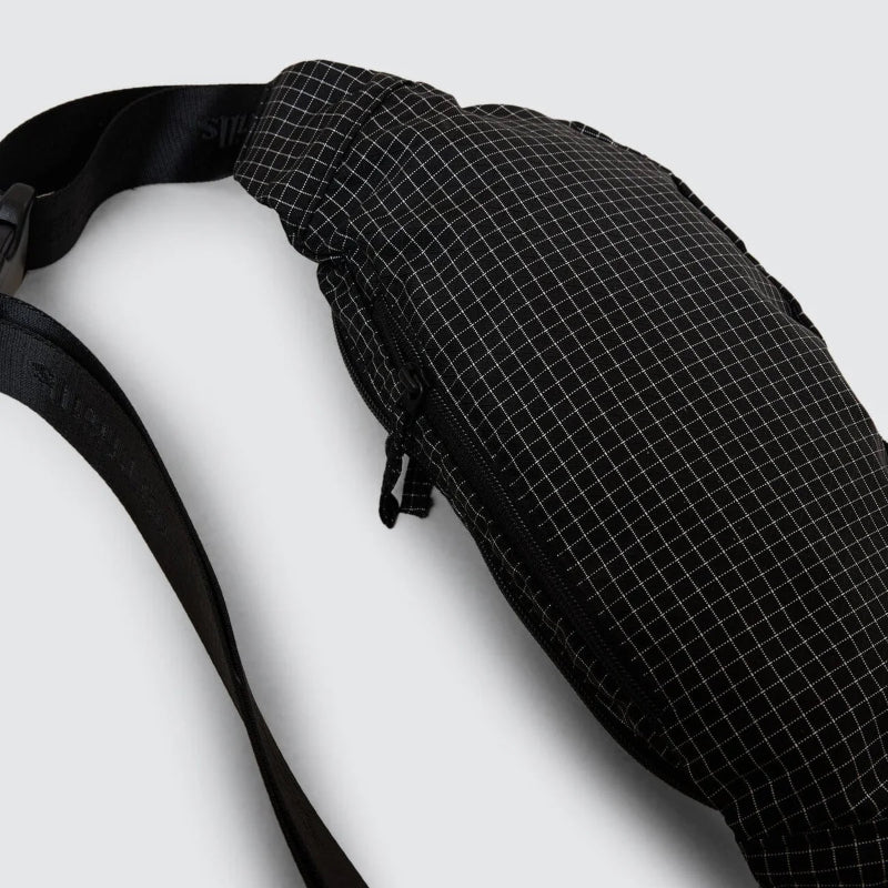 Black grid-patterned sling bag on a white background