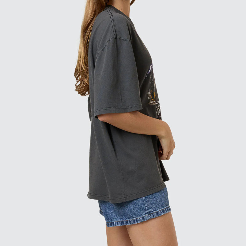 Woman wearing a dark gray t-shirt and denim shorts on a light gray background